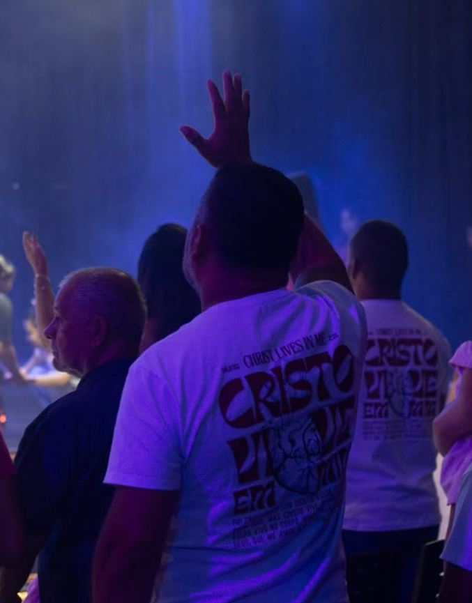 Igreja com as mãos levantadas em adoração durante o culto